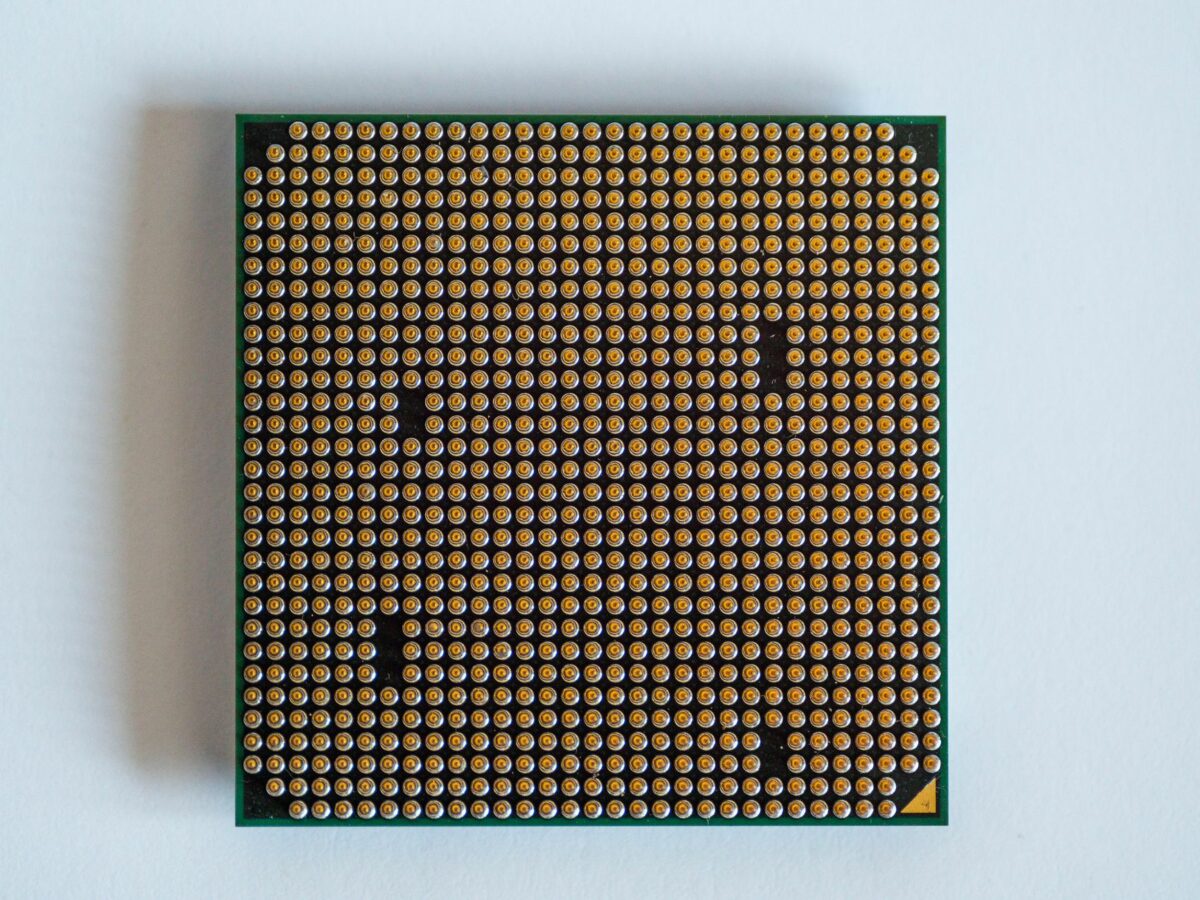 Detailed view of a computer processor, showcasing its pins, against a clean white backdrop.